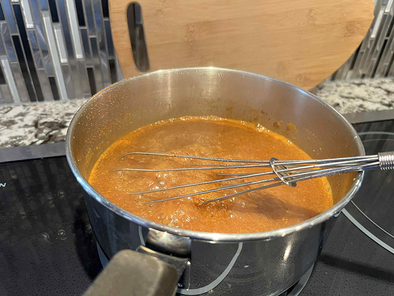 Poutine gravy with Cajun Seasoning mixed in - aboil on the stove!